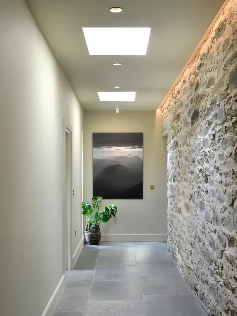 Hallway with Exposed Stone Wall at Aodin